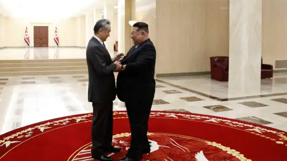 金正恩与王毅紧紧握手后拥抱