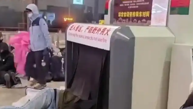  游客在车站安检机上睡觉过夜