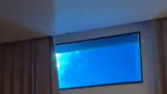 女子酒店房间拉开窗帘是泳池水底