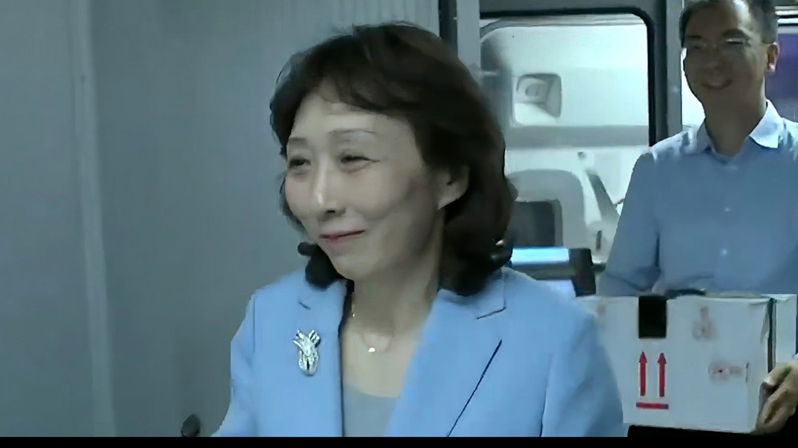  工作人员抱着到家的国宝嘴角压不住