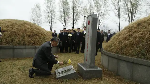 王毅单膝跪地向志愿军先烈献花