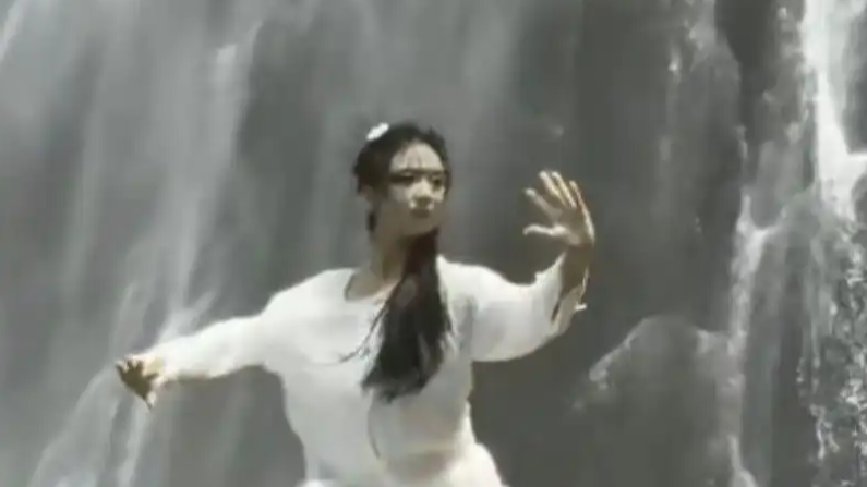  00后女生瀑布前展示太极拳