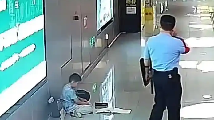 地铁站孩子趴地上写作业 辅警搬板凳
