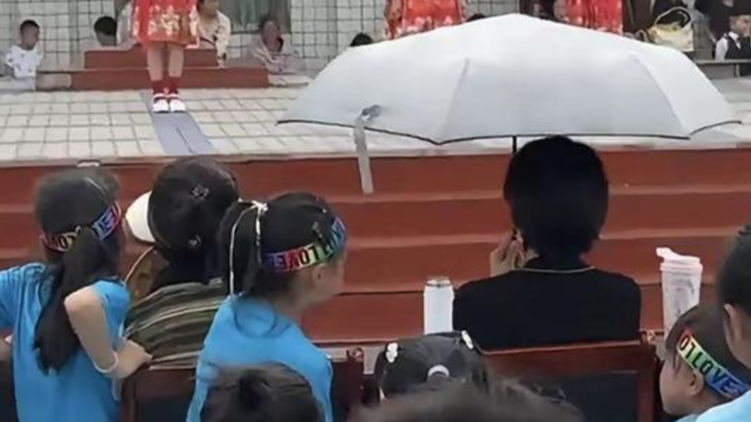  六一演出观众席C位老师独自打伞