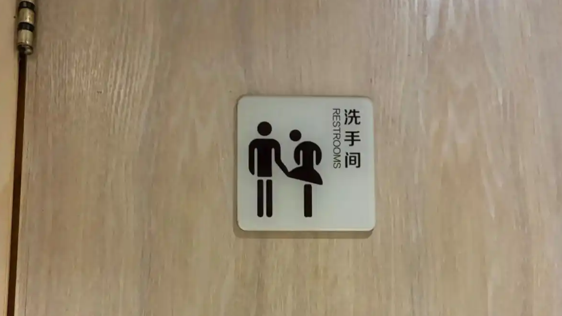 餐厅厕所标识引争议 店家：别人贴的