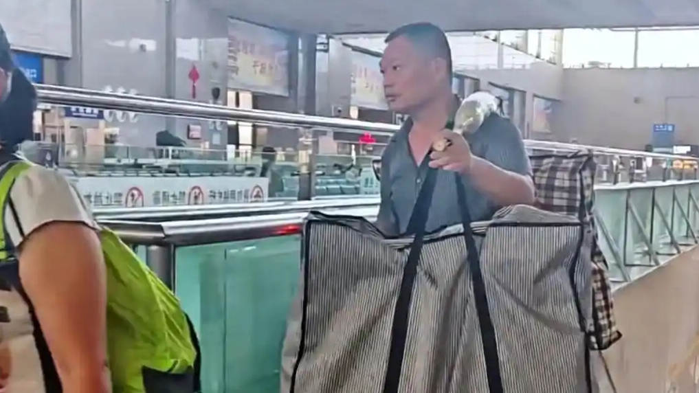 父亲挑着扁担送儿子上大学